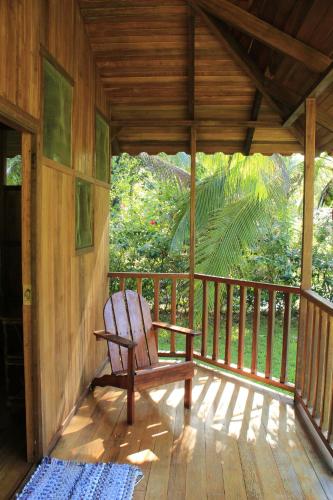 a wooden porch with a chair on a deck at Sabalo Lodge Tours and Cabins in Sierpe