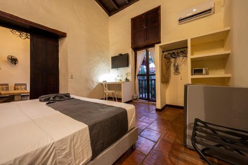 1 dormitorio con 1 cama y TV en una habitación en Casa BuGo, en Cartagena de Indias