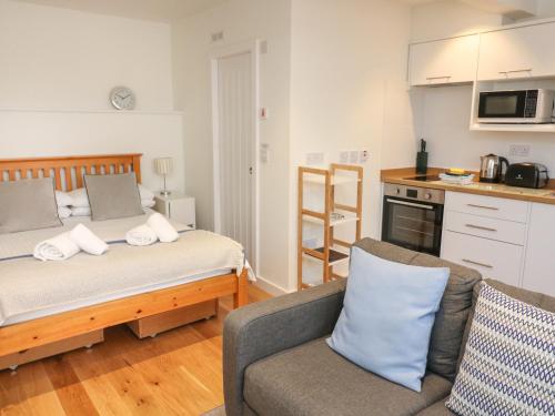 Cet appartement comprend une chambre avec un lit et un canapé ainsi qu'une cuisine. dans l'établissement The Mew, à Dartmouth