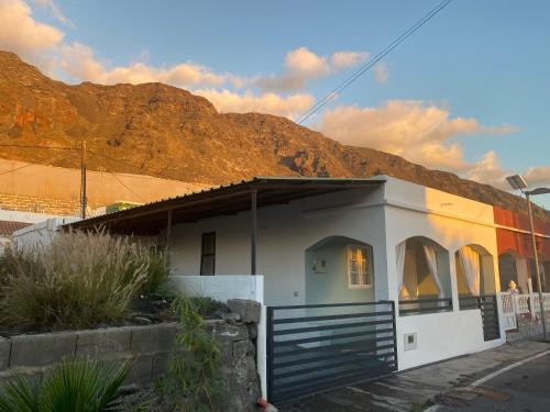 una pequeña casa con una puerta frente a una montaña en Casa “Doña Gloria”, en Los Llanos de Aridane
