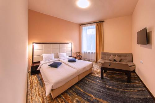 1 dormitorio con 1 cama grande y 1 sofá en Vanadzor Armenia Health Resort & Hotel, en Vanadzor
