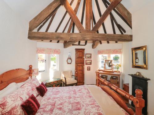 a bedroom with a large bed with a wooden frame at Pike Cottage in Acton Turville