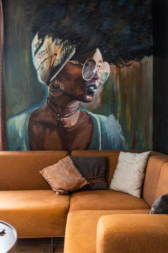 a painting of a woman wearing sunglasses on a couch at Bella Roe Premium Apartments in Belgrade