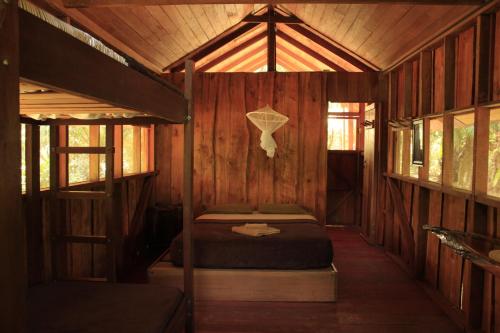a room with two beds in a wooden cabin at Sabalo Lodge Tours and Cabins in Sierpe