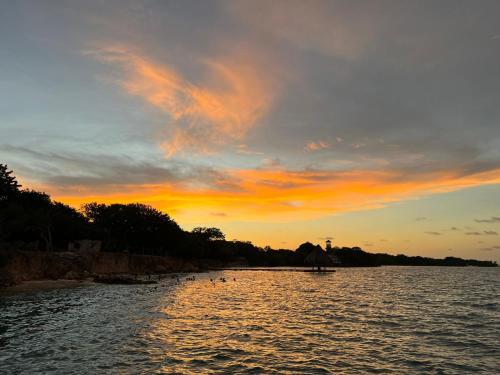 a sunset on a river with ducks in the water at Rosario EcoHotel in Isla Grande