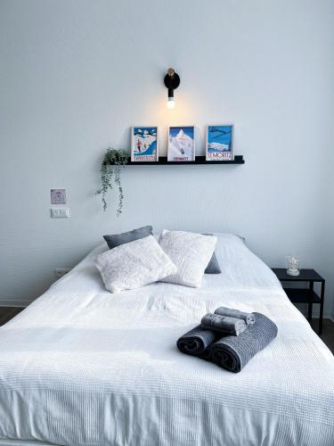 un lit blanc avec deux serviettes dessus dans l'établissement LA MASCOTTE, à Saint-Louis