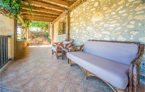 a bench sitting on a patio with a stone wall at Stunning Home In Les Coves De Vinromá in Les Coves de Vinroma