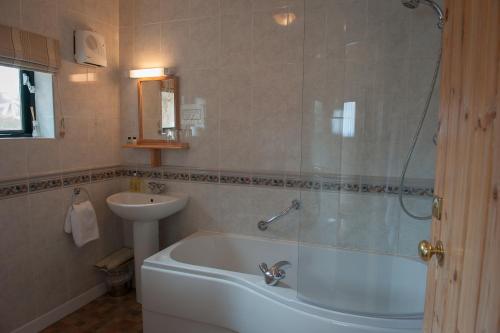 a bathroom with a tub and a sink at The Langton Arms in Blandford Forum