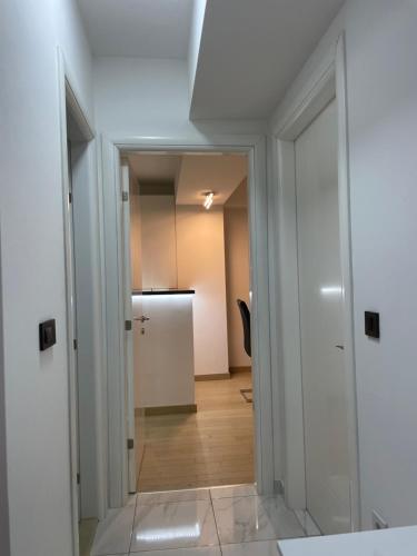 a hallway with a door leading to a kitchen at Luka Apartments Flatiron in Skopje