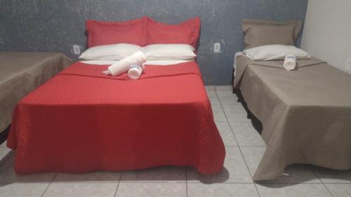 a red bed with towels on top of it at Pousada o Canto da Seriema in Nobres
