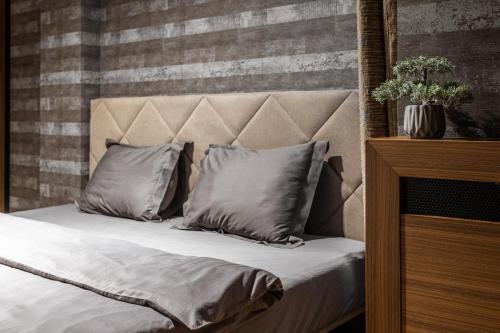 a bed with two pillows on top of it at Bella Roe Premium Apartments in Belgrade