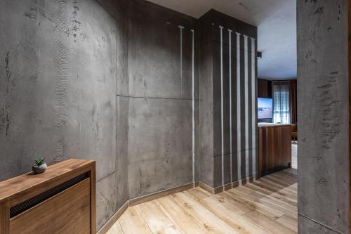 a living room with a concrete wall and wooden floors at Bella Roe Premium Apartments in Belgrade