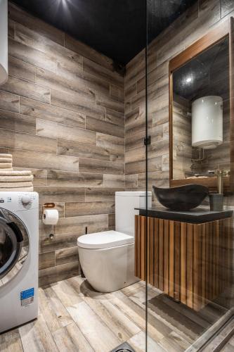a bathroom with a toilet and a sink and a washing machine at Bella Roe Premium Apartments in Belgrade