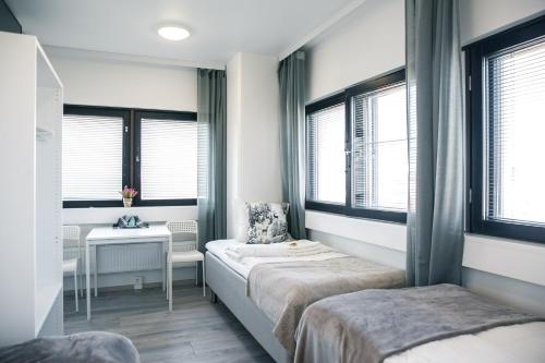 a bedroom with two beds and a desk and windows at Inn Tourist Hostel in Helsinki