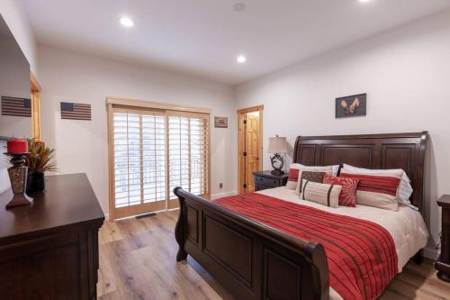 a bedroom with a large bed with a red blanket at Hillside Hideaway - game rm - master spa - Luxury in Lake Arrowhead