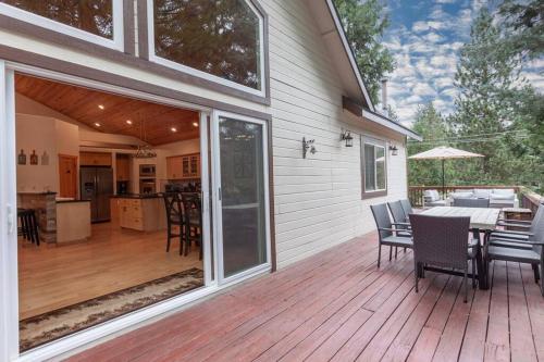 a patio with a table and chairs on a deck at Hillside Hideaway - game rm - master spa - Luxury in Lake Arrowhead