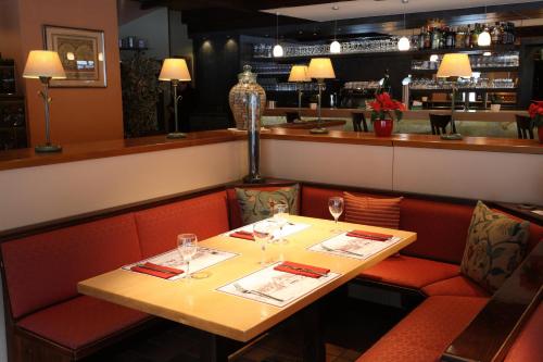 un restaurant avec une table, des chaises et des verres à vin dans l'établissement Hotel Sieweburen, à Luxembourg