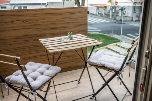 a wooden table and two chairs on a balcony at Bella Roe Premium Apartments in Belgrade