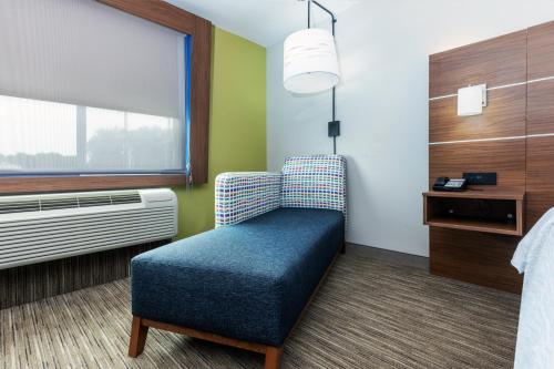 a room with a chair and a window at Holiday Inn Express & Suites Lafayette South by IHG in Lafayette