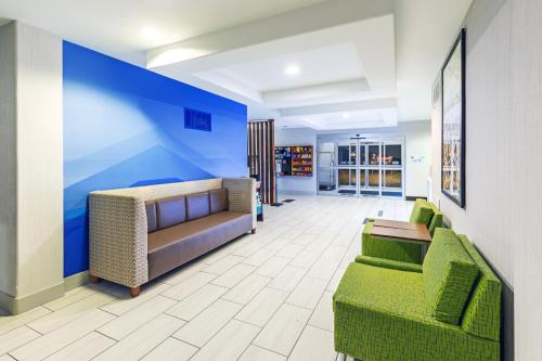 a lobby with two couches and a blue wall at Holiday Inn Express & Suites Lafayette South by IHG in Lafayette