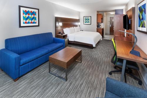 a hotel room with a couch and a bed at Holiday Inn Express & Suites Lafayette South by IHG in Lafayette
