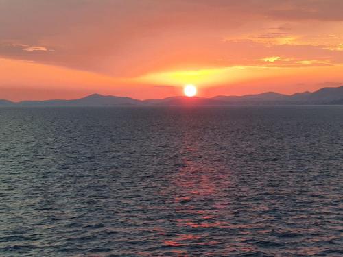 a sunset over the ocean with mountains in the background at Luxury Villa Sun Stone heated pool & whirlpool in Trogir
