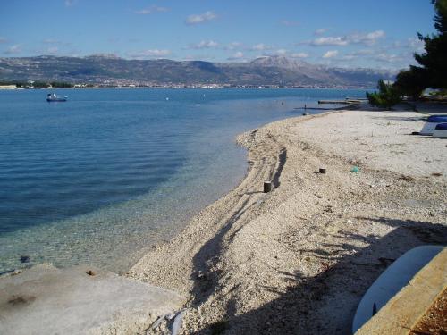 a beach with a boat in the water at Luxury Villa Sun Stone heated pool & whirlpool in Trogir