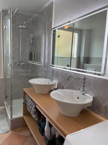 La salle de bains est pourvue de 2 lavabos et d'une douche. dans l'établissement Black Forest Apartment, à Baden-Baden