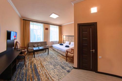 Habitación de hotel con cama y sofá en Vanadzor Armenia Health Resort & Hotel, en Vanadzor
