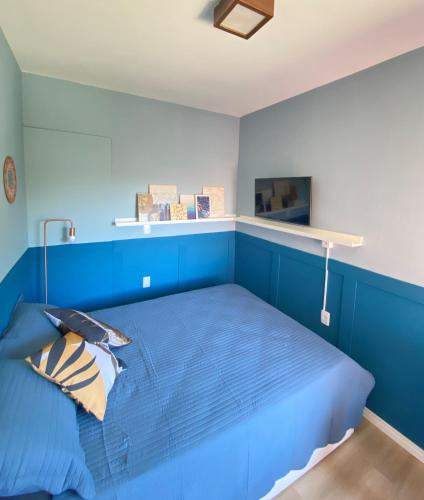 a blue bedroom with a bed with a blue wall at Duque Hostel in Florianópolis