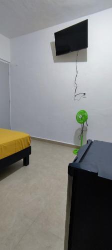 a room with a bed and a green chair at Casa en Mahahual cerca de la playa D4 in Mahahual