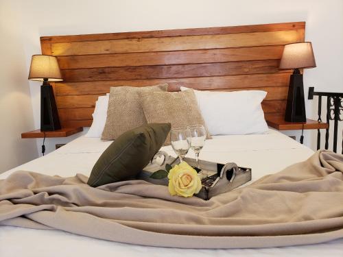 a bed with a blanket and two glasses of wine at Loft Terrazas de Cachagua in Zapallar