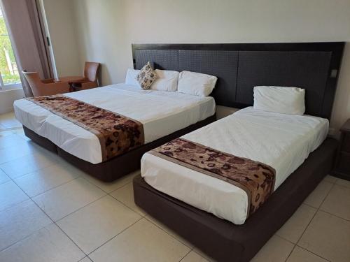dwa łóżka siedzące obok siebie w pokoju w obiekcie Trans International Hotel w mieście Nadi