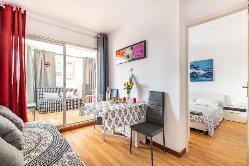 een woonkamer met een tafel en een slaapkamer bij Dream House in Badalona