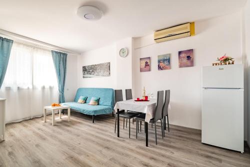 uma sala de estar com um sofá azul e uma mesa em Dream House em Badalona