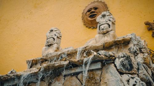 two statues on the side of a building at Hotel Mucuy in Mérida