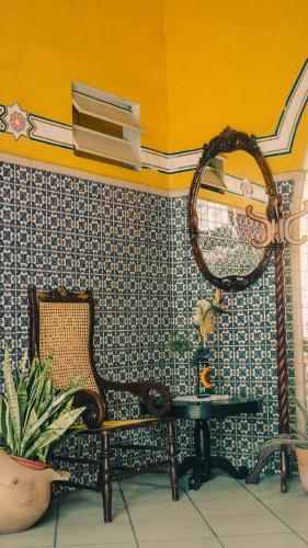 a room with a chair and a mirror on a wall at Hotel Mucuy in Mérida