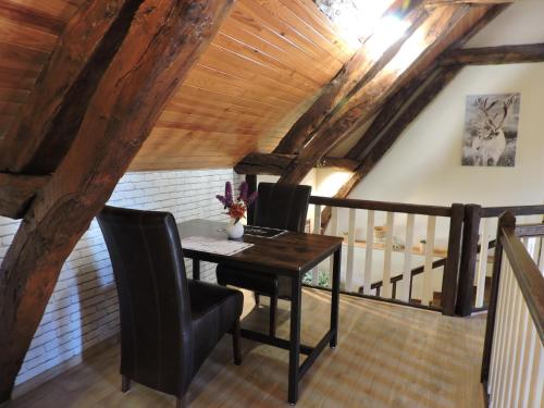 une salle à manger avec une table et deux chaises dans l'établissement L'échappée belle, à Ricarville