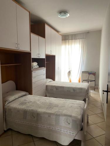 Zimmer mit 3 Betten und einem Fenster in der Unterkunft Casa Luisini in Mondovì