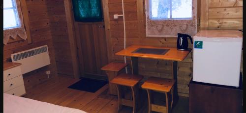 a small kitchen with a table and stools in a cabin at Artur´s Eaterie and Holiday home in Viitna