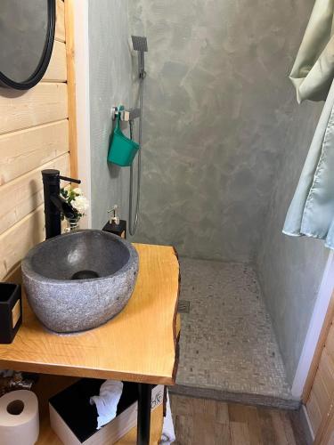 La salle de bains est pourvue d'un lavabo en pierre sur un comptoir en bois. dans l'établissement La cabane de l'étang, à Kerprich-aux-Bois