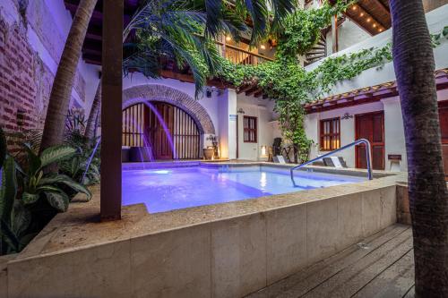 una gran piscina en un edificio con palmeras en Casa BuGo, en Cartagena de Indias