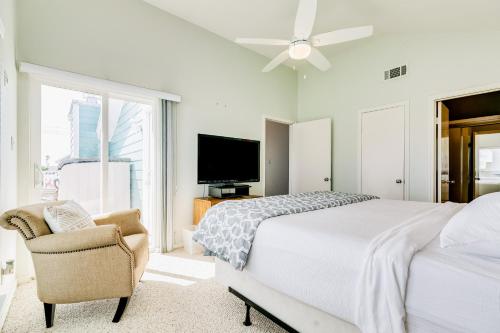 Schlafzimmer mit einem Bett, einem TV und einem Stuhl in der Unterkunft Slice of Paradise in Galveston