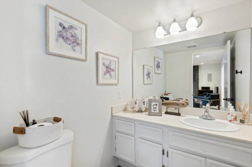 a white bathroom with a sink and a mirror at Mira Costa Majesty in Oceanside