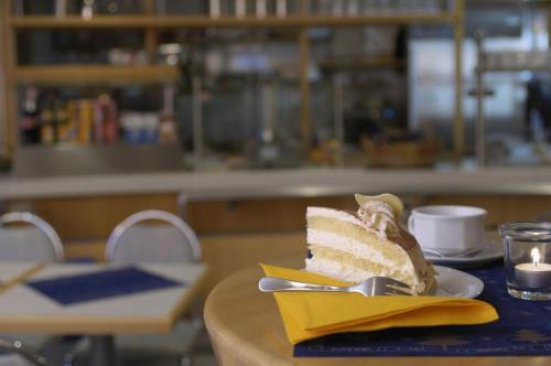 un trozo de pastel en un plato en una mesa en Hotel am Holzhafen en Stade