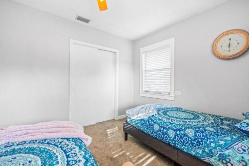 a bedroom with two beds and a clock on the wall at Don't Be Koi in Bradenton