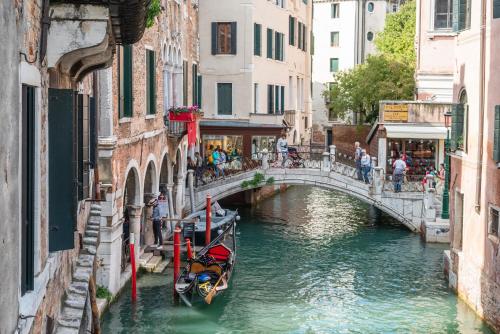 a canal in a city with a bridge and a boat at Hotel al Sotoportego in Venice