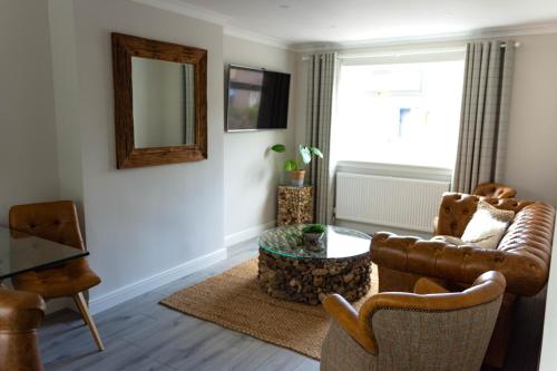 a living room with a couch and a table and a mirror at Lovely 2 bed house in Pitlochry in Pitlochry