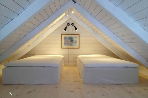 1 dormitorio en el ático con 2 camas y percha en Sjöstugan, Solviken en Rockneby