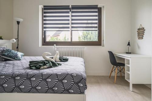 een slaapkamer met een bed, een bureau en een raam bij LE LOTUS - Self Checkin - 20min from Paris - Free Parking around in Drancy